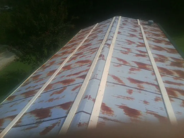Rusted metal roof panels with new wood purlins before replacement — Storm Damage Roof Repair in Amanda by Roofing Brothers