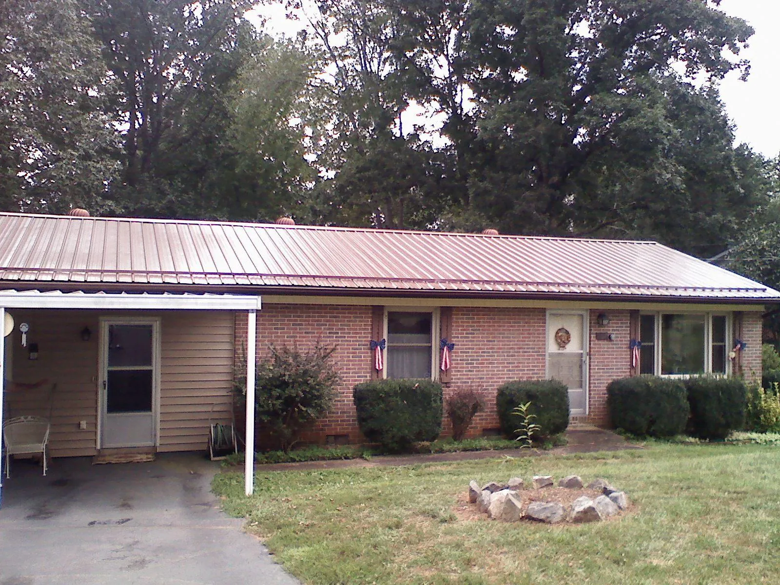 Bronze metal roof and carport on a brick ranch home — Roof Repair work by our crew in Amanda